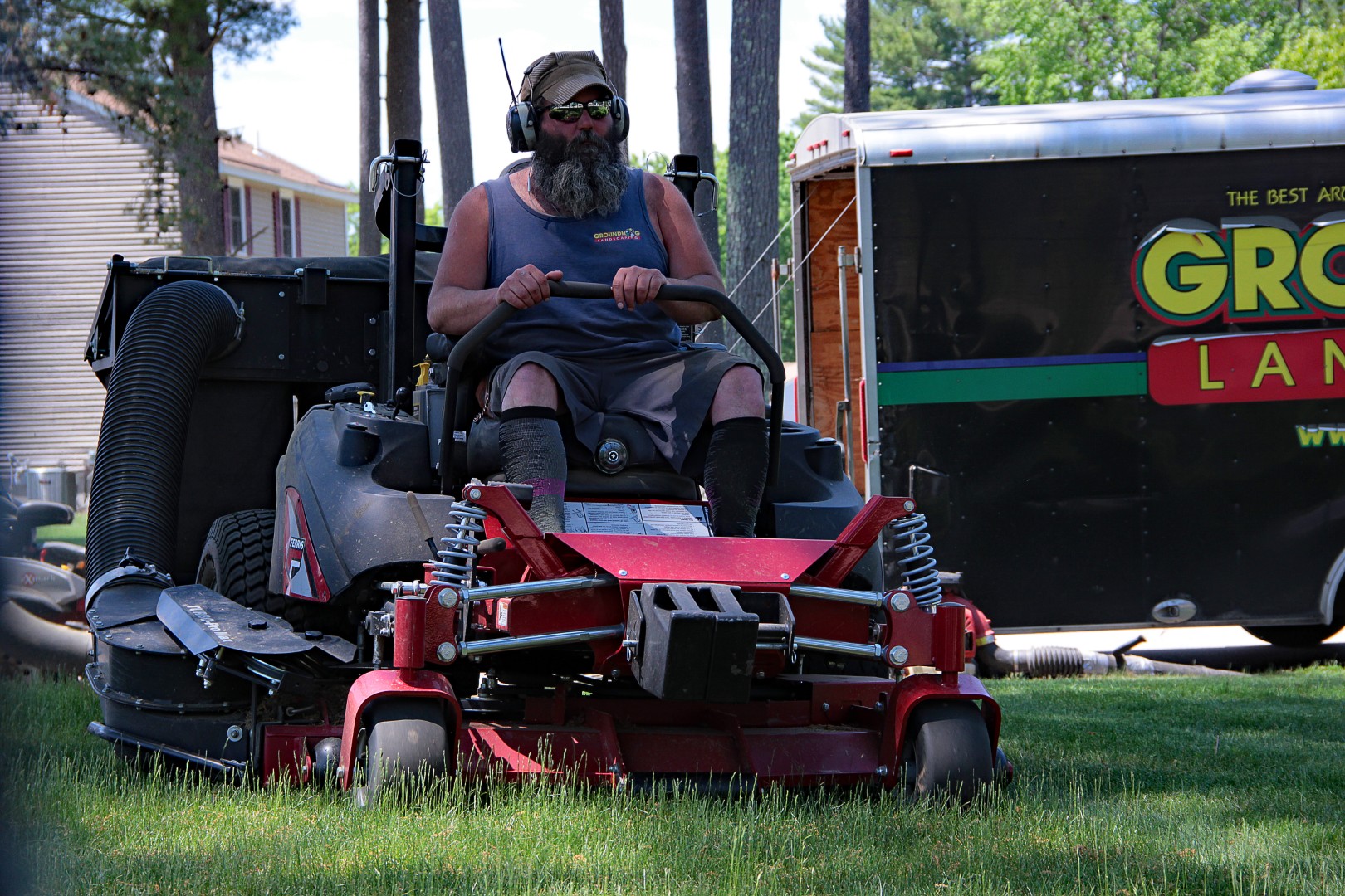 Man operating a commercial lawn mower for Groundhog Landscaping, focused on lawn care and maintenance in Nashua, NH.