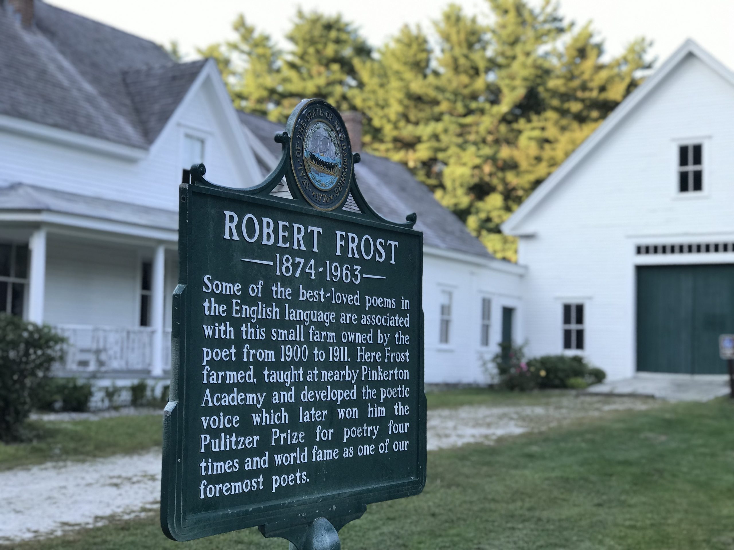 Sign for Robert Frost at his historic farm in Derry, NH, highlighting his contributions to literature and connection to Pinkerton Academy.