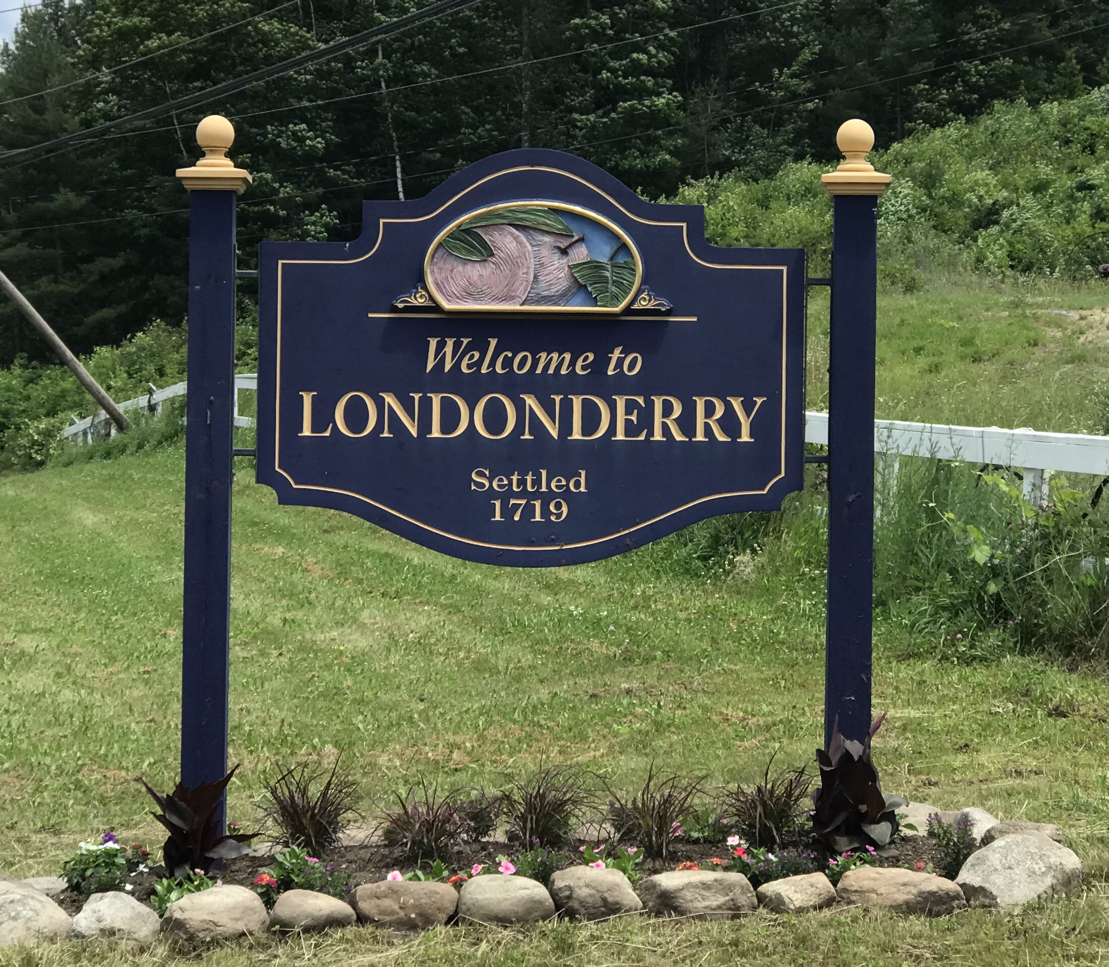 Welcome sign for Londonderry, NH, featuring "Welcome to LONDONDERRY" and "Settled 1719," surrounded by decorative flowers and greenery.