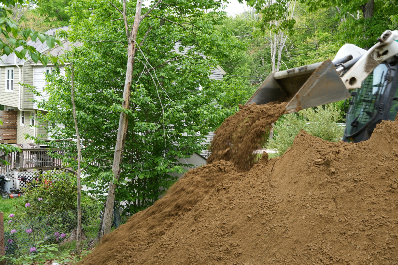 skid steer loader filling property with loam