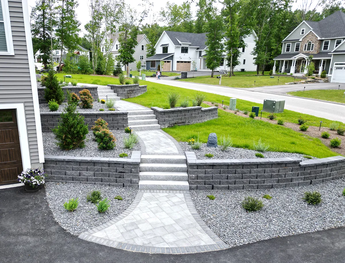 Multi-tier segmental retaining walls and paver steps built on New Hampshire hillside
