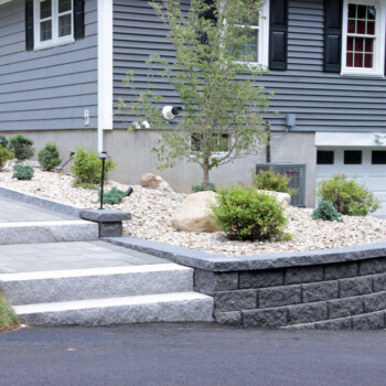 Paver patio and granite steps hardscape design by Groundhog Landscaping in Derry, NH.